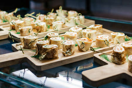 Meat rolls on a cutting board on a glass tableの写真素材