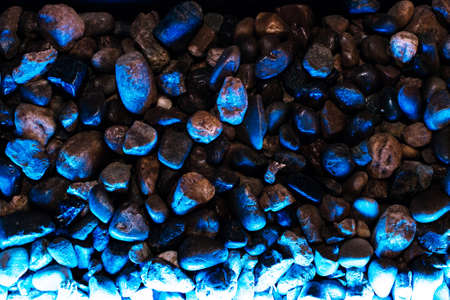 Small decorative stones with blue backlight in dark colorsの写真素材