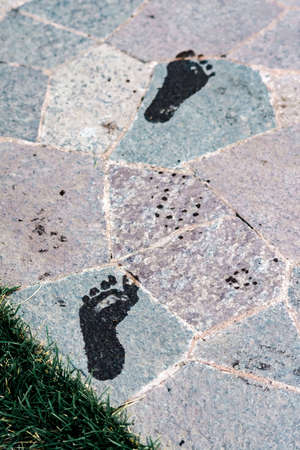 Wet footprints on a stone tile close upの写真素材