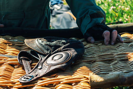 A pilot hat on a wicker basket on a sunny day
