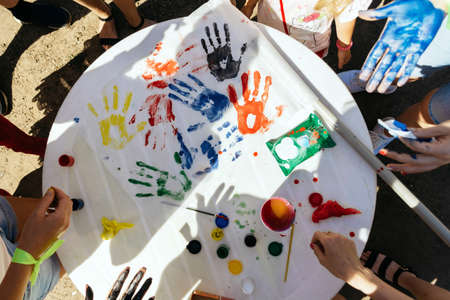 Multi-colored handprints on paper in team play