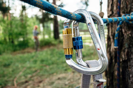 Climbing carabiner and rope in the forest in summer close up