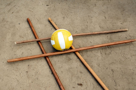 Volleyball ball on wooden sticks on the sand for a team game