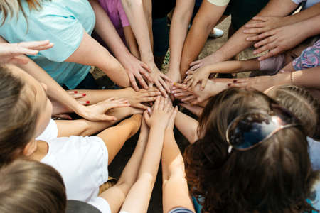 Many female hands are woven together in a team gameの写真素材