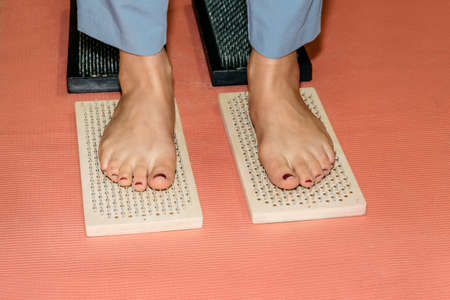 Woman feet on a path made of Sadhu boards on a red backgroundの写真素材