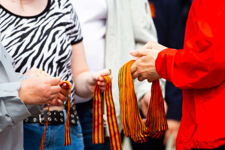St. George's ribbons and people's hands close-upの写真素材
