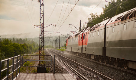 The electric locomotive leaves in the fog. The train is moving at high speed into the distance.の写真素材