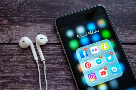 New York / USA - 12/04/2019: Black Apple iPhone with icons of social media: instagram, youtube, facebook, pinterest, twitter, snapchat application on screen. Social media icons. Marketing concept.のeditorial素材