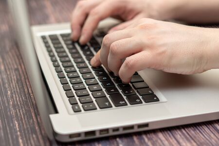 People chatting with friends in social networks or media. Can be used as an illustration for news, marketing or business concept. Hands and laptop with black keys. Daytime natural lighting.のeditorial素材