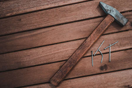 The old carpenter hammer to hit the nails on the wooden table. Wood backgroundの写真素材
