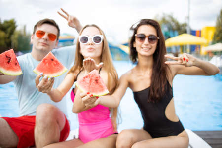 Young couple in love relaxing by the pool. Summer party at the city pool. Having fun, dance and enjoy time with friends.の写真素材