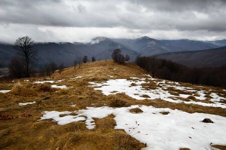 Stormy mountains with snow peaks on distanceの写真素材