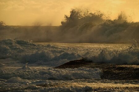 Moody sunrise seascape with colored clouds and flowing waterの写真素材