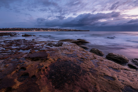 Seascape sunrise long exposure with flowing water and violet skyの写真素材