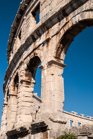 Old ruined Colliseum in Pula, Croatia during the day with blue skyの写真素材