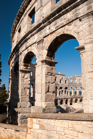 Old ruined Colliseum in Pula, Croatia during the day with blue skyの写真素材