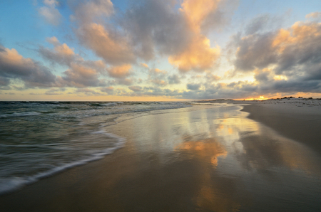 Tropical paradise beach with bright smooth mirror sand and crystal clear water during sunsetの写真素材