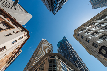 Five tall buildings viewed from bottom looking up with blue sky during the dayの写真素材