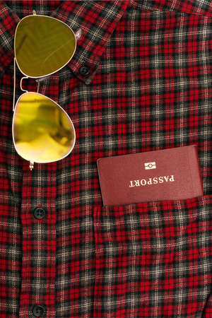 Male checkered cowboy's shirt with a passport in the pocket and sunglassesの写真素材