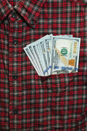 Male checkered cowboy's shirt with unsafely stored money in the pocket