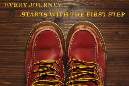 Old worn, but still sturdy boots shooted in POV style with motivation tagline shooted on the wooden floorの写真素材