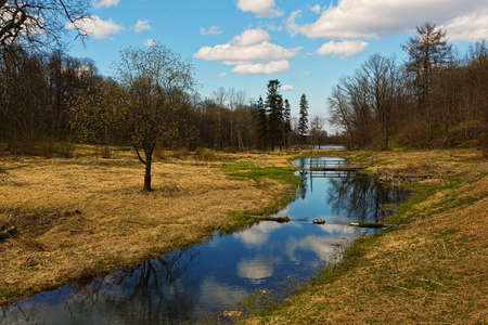 Spring or autumn landscape with river, meadows, forest and dramatic skyの写真素材