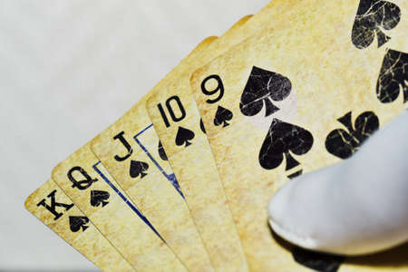 Playing cards with a spades combination in man hand in white glove