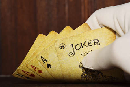 Poker cards combination holded in man hand in white glove