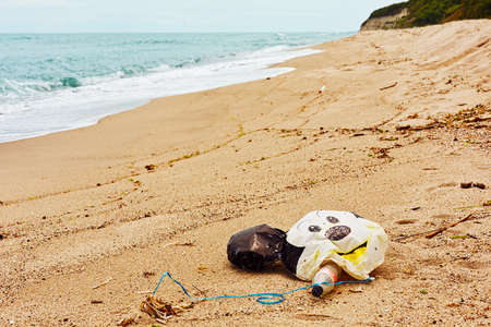 Old chilfren's balloon, plastic bottles and bags and oher garbage left on sand beachのeditorial素材