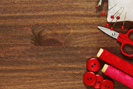 Sewing tools and handicraft materials on thw wooden table in flat closeup viewの写真素材