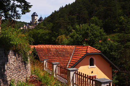 KARLSTEIN, CZECH REPUBLIC - JULY 10, 2016: Medieval castle rises over the town buildingsのeditorial素材