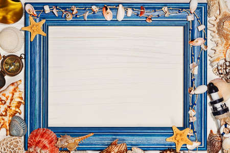 Mediterranean concept with blank rough painted frame and sea shells, star fish and vintage metal compassの写真素材