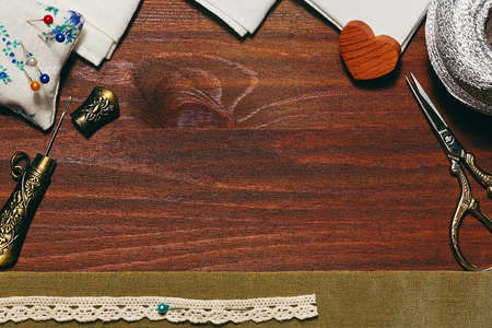 Handicraft accessories and materials on wooden plank background in top flat view