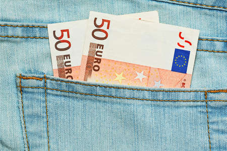 Two fifty euros bank notes in jeans pocket. Small allowance or minimal salary conceptの写真素材