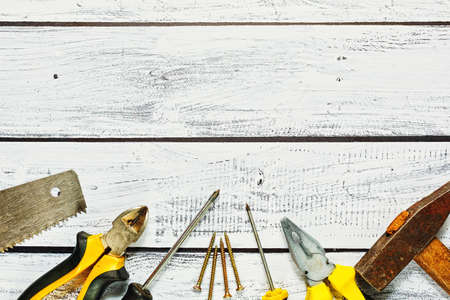 Handyman workspace concept - different hand tools and items looks used on the wooden table in top viewの写真素材