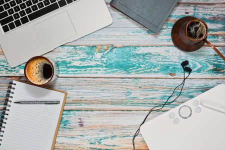 Freelancer designer or illustrator workplace with laptop, graphics tablet and traditional copper...