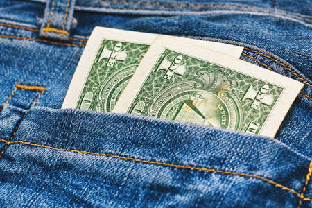 Only two one dollar notes in worn jeans pocket. Close up capture, blur focus, old banknotes.の写真素材