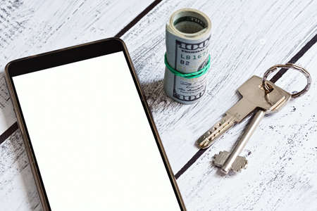 Searching, renting and purchasing real estate - apartment or house via smartphone mobile app. Close-up capture, selective focus.の写真素材