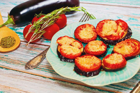 Cooking recipe idea. Healthy organic dish of mediterranean cuisine - grilled eggplants with tomatoes, cheese, spices and herbs mix. Healthy dieting concept. Close-up capture.の写真素材