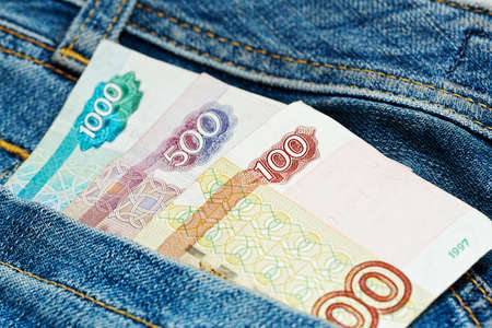 Small sum in russian rubles - around 25 US dollars or 20 euros - in worn blue jeans pants pocket....