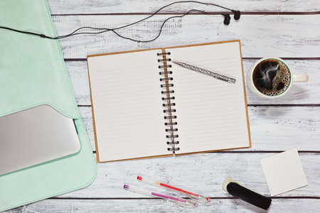 Working place in loft style on wooden desk of student or freelancer - laptop in case, opened blank...