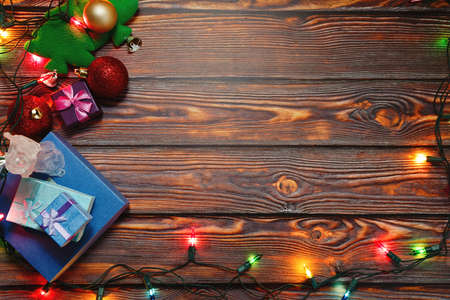 Wooden background with Christmas and New Year decorations and symbols - heap of gift boxes,...