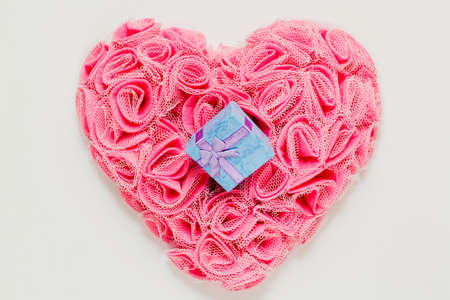 Romantic ready to present gift in tiny box on heart shaped ornament made of man-made rose blossoms...