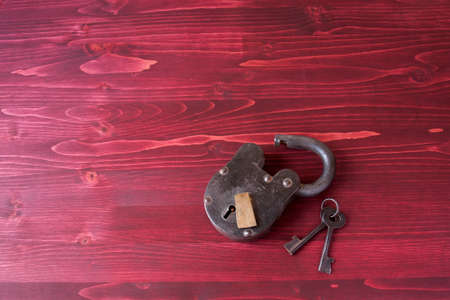 Old Fashioned Lock and Keys on a Red Wooden Backgroundの写真素材