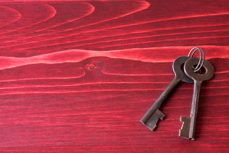 Old Fashioned Keys on a Red Wooden Backgroundの写真素材