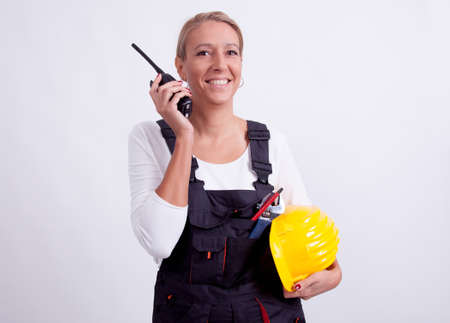 Female construction worker with tools on white の写真素材
