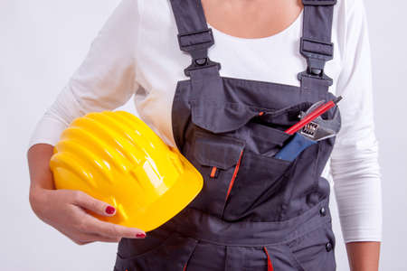 Female construction worker with tools on white の写真素材
