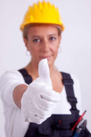 Female construction worker with tools on white の写真素材