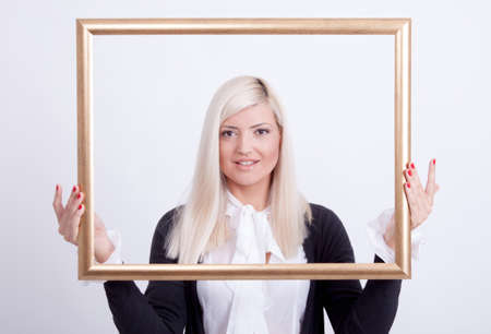 Portrait of a young blond woman holding a frame