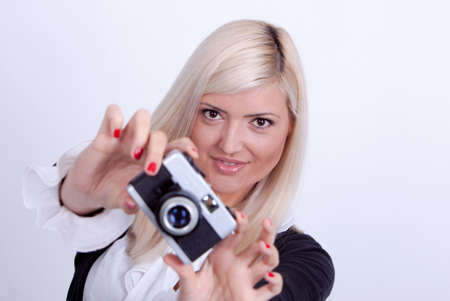 Blonde woman photographing over white backgroundの写真素材